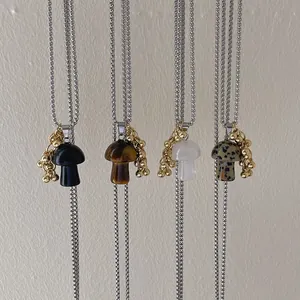 Detail of four mushroom gemstone pendants including obsidian and tiger eye on silver chains