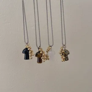 Minimalist mushroom pendant necklace featuring stone textures and golden bead accents