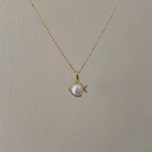 Elegant gold fish pendant necklace with freshwater pearl and zircon stones on a fine chain