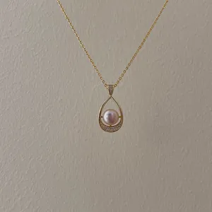 Macro view of water-drop gold pendant with pink freshwater pearl and fine zircons