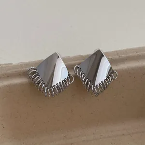 Detail of silver geometric stud earrings with spiral tassel fringe on craft card