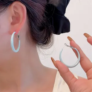 Detail of light blue glazed hoop earrings showing silver buckle and wear effect