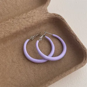 Detailed view of lavender purple matte hoop earrings on natural pulp tray background
