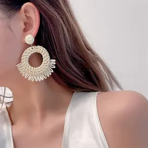 Bohemian off-white woven raffia hoop earrings with fringe detail for beach vacation style