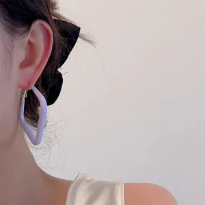 Close-up of minimalist lavender geometric earring with silver buckle on model ear