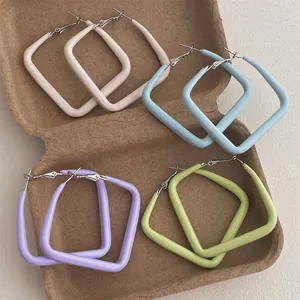 Macro view of four pairs of colorful matte square hoop earrings in pastel macaron shades
