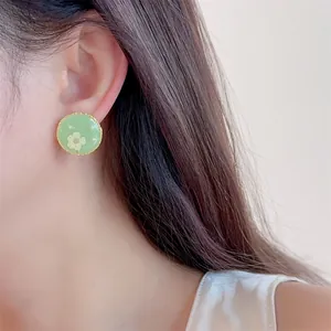French vintage green enamel flower earrings with pearls and gold serrated edge on model