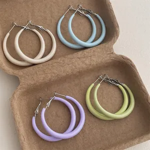 Set of four pastel colored hoop earrings in macrame style tray for women