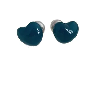 Glossy teal heart-shaped earbud attachments with a double-sided pearl design