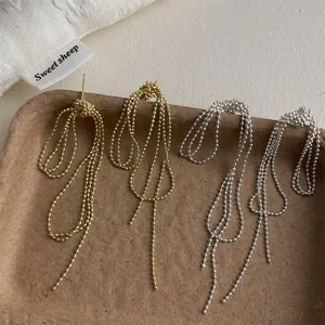 Detail view of long tassel chain earrings in gold and silver finish with S925 silver needles