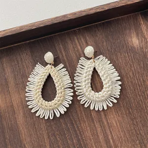 Handmade cream teardrop raffia earrings with woven fringe for beach vacation style