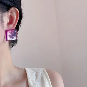 Detail of square acrylic marble earring in purple and white worn on ear lobe