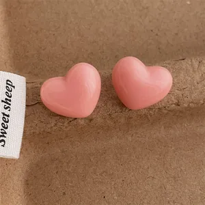 Close-up of sweet candy-colored pink heart studs on textured background with high gloss finish