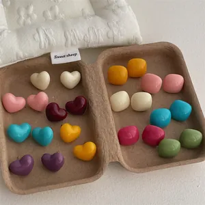 Macro shot of colorful heart and square resin stud earrings in various candy colors