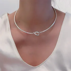 Nahaufnahme eines minimalistischen silbernen Knoten-Chokers an einem Model mit V-Ausschnitt