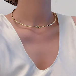 Detail eines minimalistischen goldenen Knotenchokers aus poliertem Edelstahl für Damen