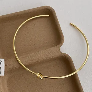 Detailansicht eines polierten goldenen Knotenchokers mit minimalistischem Design