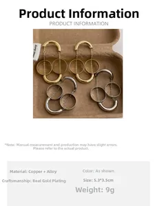 Dettaglio macro di orecchini geometrici con nappe placcati in oro e argento su legno