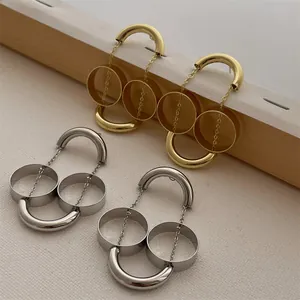 Dettaglio di orecchini geometrici a doppio anello argento e oro con finitura lucida