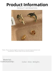 Detail view of enamel whale shark and dolphin brooches with golden butterfly clutch backings
