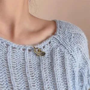 Artistic whale shark enamel brooch with gold plating pinned on a blue knitted sweater