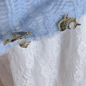 Cute whale shark enamel pins set with gold metal finish on blue knitted fabric