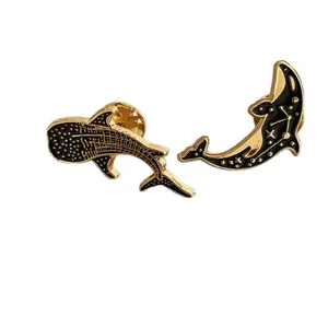 Enamel whale and dolphin pin set with celestial star patterns and gold plating