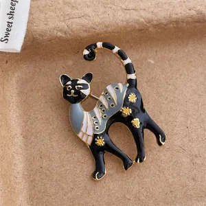 Detail einer Emaille-Katzenbrosche mit Blumenmuster auf rustikalem braunem Papier