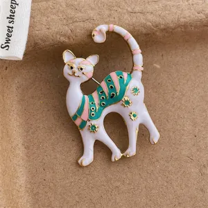 Nahaufnahme der süßen weißen Katzenbrosche mit bunten Streifen und Emaille-Details