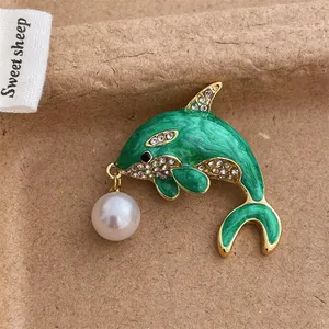 Green enamel dolphin brooch with sparkling rhinestones and a white pearl drop pendant