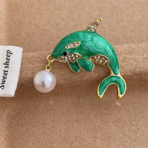 Green enamel dolphin brooch with sparkling rhinestones and a white pearl pendant