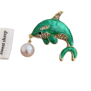 Green enamel dolphin brooch with white zircon fins and a pink pearl drop pendant