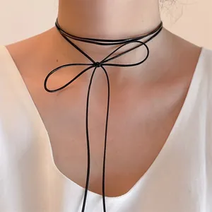 Detalle de collar gargantilla de cinta negra con un lazo atado a mano en el cuello