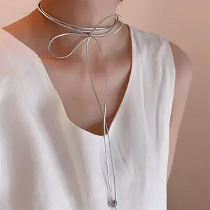 Detalle del collar choker de lazo metálico plateado con cordones largos colgantes