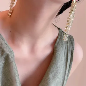 Elegantes pendientes largos de lentejuelas doradas con cristales para un estilo chic