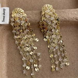 Elegantes pendientes largos dorados con borlas, lentejuelas brillantes y cuentas de cristal