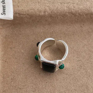 Detailed shot of vintage silver ring with irregular green malachite and black stones