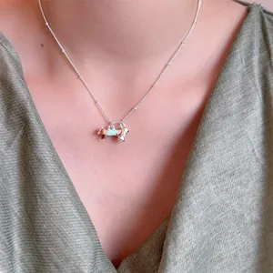 Detail van teckel- en botvormige hangers aan een kralenketting voor dames sieraad