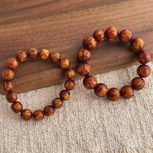 Vista dettagliata di due braccialetti di perle di legno marrone dorato su fondo rustico