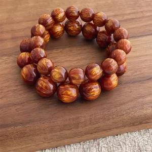Braccialetti di perle di legno cinese lucidati con trama dorata su fondo di noce scuro