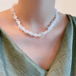 Irregular white crystal stone necklace featuring a large raw stone pendant on a model