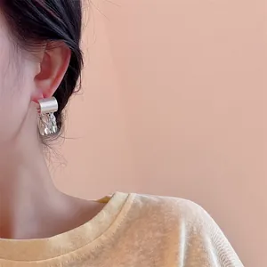 Gros plan de boucles d'oreilles feuilles à pampilles argentées portées par un mannequin