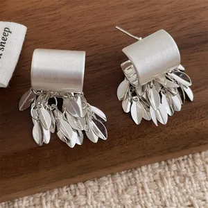 Macro d'oreilles à franges de feuilles argentées sur texture bois foncé et détails