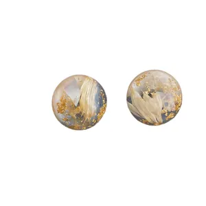 Minimalist resin ball earrings with embedded white dried flowers and gold foil accents