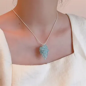 Detailed close-up of light blue grape cluster pendant on a silver snake chain necklace