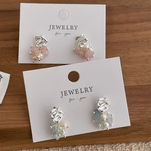 Detailed close-up of French-style tassel earrings with natural stones and pearls
