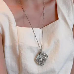 Detail van de zilveren geweven rechthoekige hanger met fijne kralen aan lange ketting