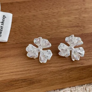 Detailed close-up of zircon flower earrings with silver brushed metal finish