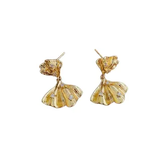 Elegant gold ginkgo leaf stud earrings with sparkling zircon crystals on white background