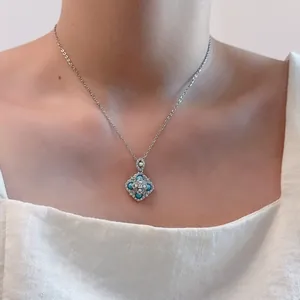 Close-up of vintage floral pendant necklace with turquoise stones and tiny pearls